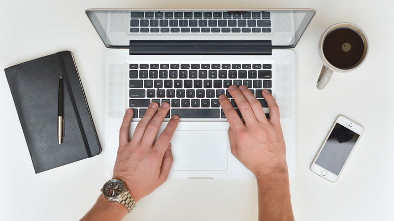 laptop with keyboard and hands