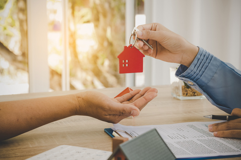 a man handing keys to another person